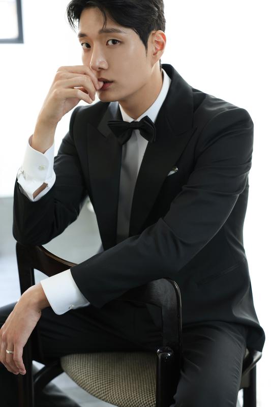 블랙 턱시도를 입고 의자에 앉은 신랑