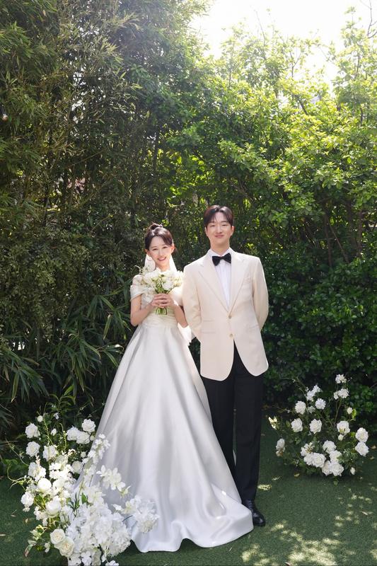 정원에서 아이보리 디너 재킷을 입은 신랑과 신부